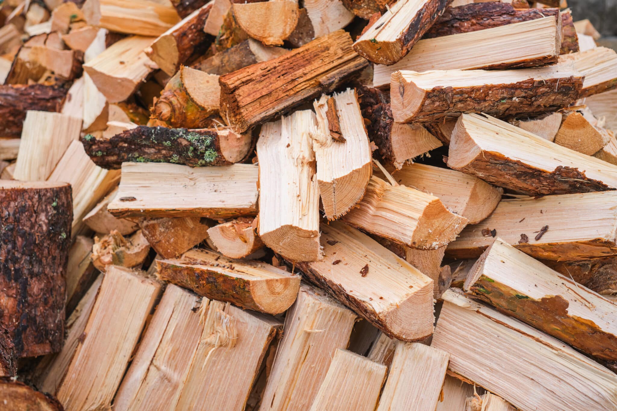 Bûches de bois sec empilées contre un mur, prêtes pour le chauffage